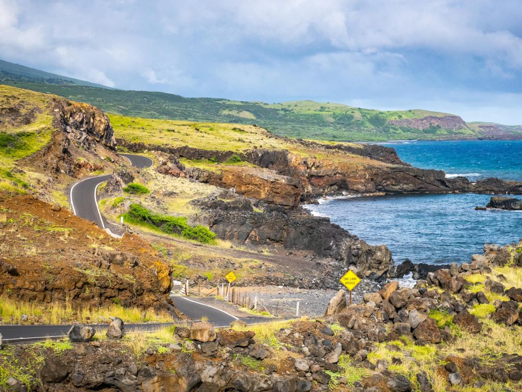 Road to Hana alongside the coastline, with steep winding highway, and rocky green landscape, Maui, Hawaii