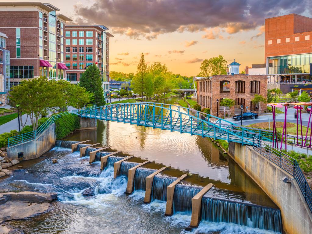 Greenville, South Carolina, USA downtown cityscape on the Reedy River at dusk.