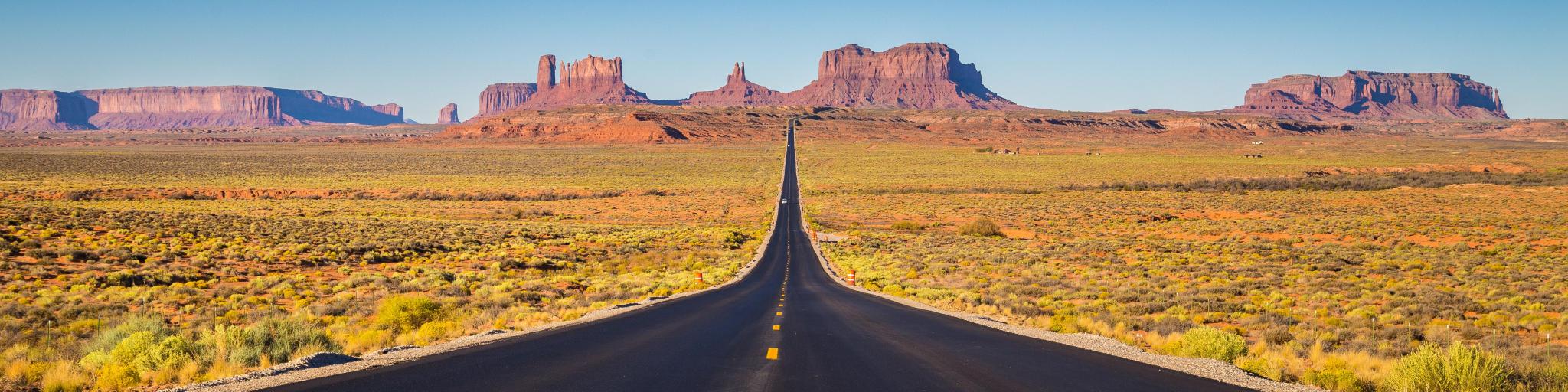 Classic panorama view of historic U.S. Route 163 running through famous Monument Valley