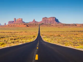 Classic panorama view of historic U.S. Route 163 running through famous Monument Valley