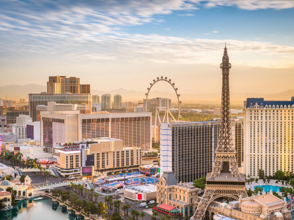 Las Vegas, Nevada, USA skyline over the strip at dusk with the iconic buildings and landmarks in the foreground and faint mountains in the background