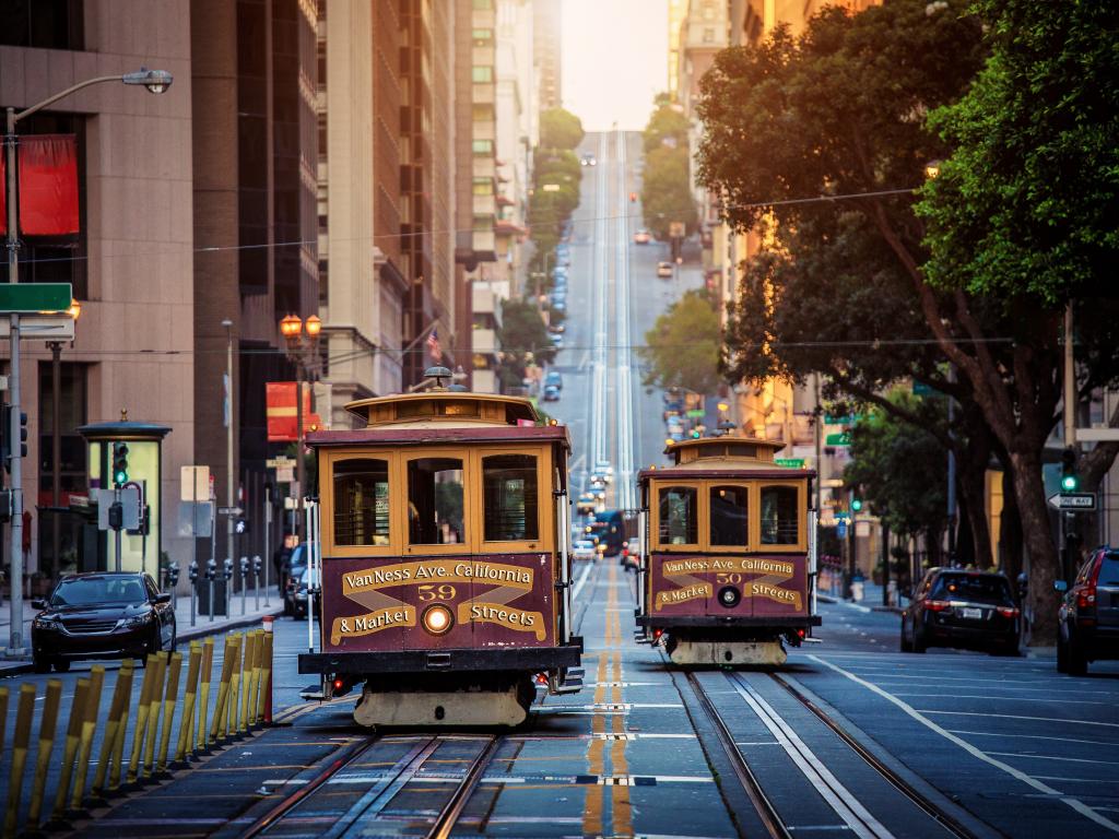 Traditional San Francisco cable cars passing each other on one of the city's steep streets.