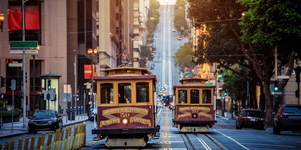 Traditional San Francisco cable cars passing each other on one of the city's steep streets.