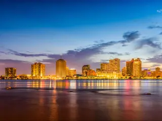 New Orleans, Louisiana, USA with the city skyline on the Mississippi River at night. 