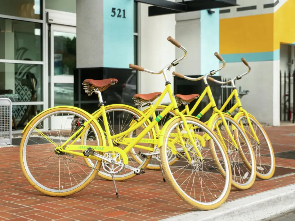 Bright yellow bicycles for hire at the bright blue and yellow entrance to Staypineapple, Hotel Z, San Diego