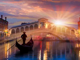 Gondola near Rialto Bridge in Venice, Italy during a dramatic sunset