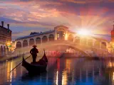 Gondola near Rialto Bridge in Venice, Italy during a dramatic sunset