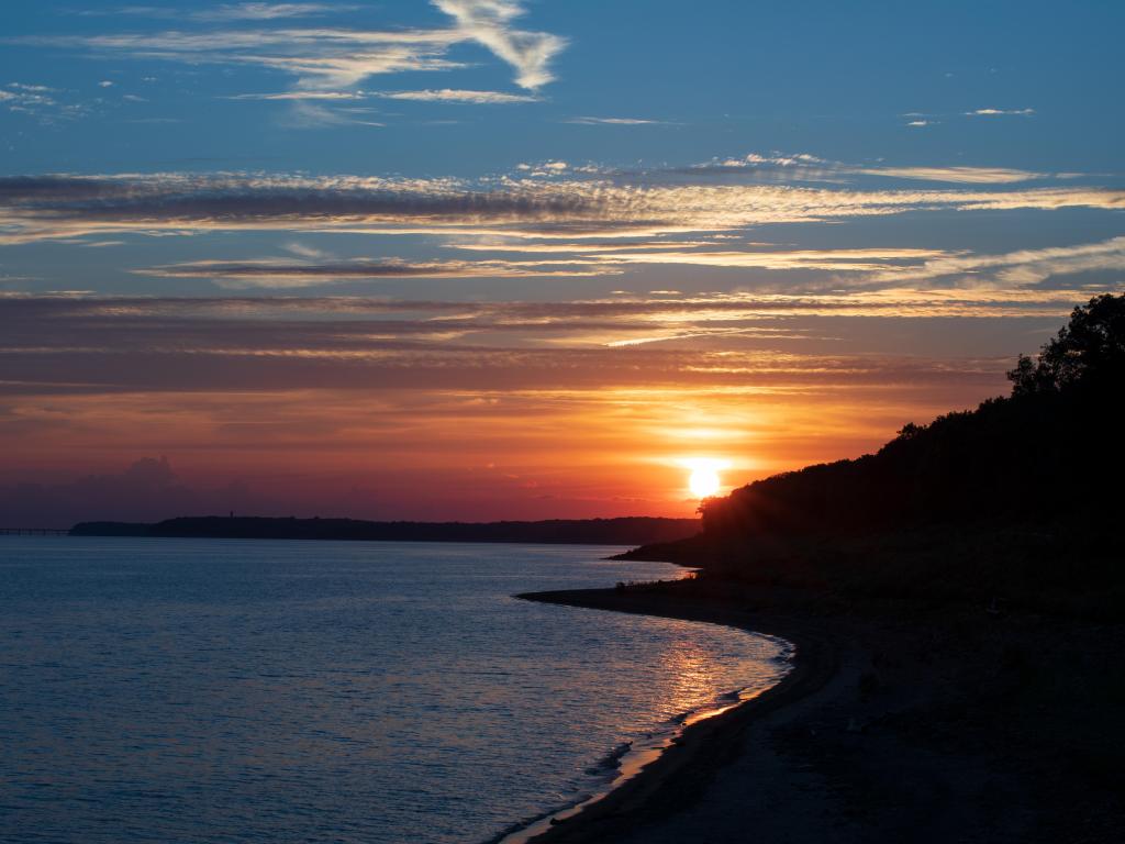 Red Sunset seen from behind a shadowed bluff, over the Des Moines River, Iowa