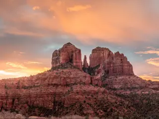 Sedona, Arizona, USA with a colorful sunrise over Sedona's Cathedral Rock landmark in the distance.
