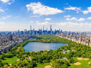 Aerial view of the Central park in New York with golf fields and tall skyscrapers surrounding the park.