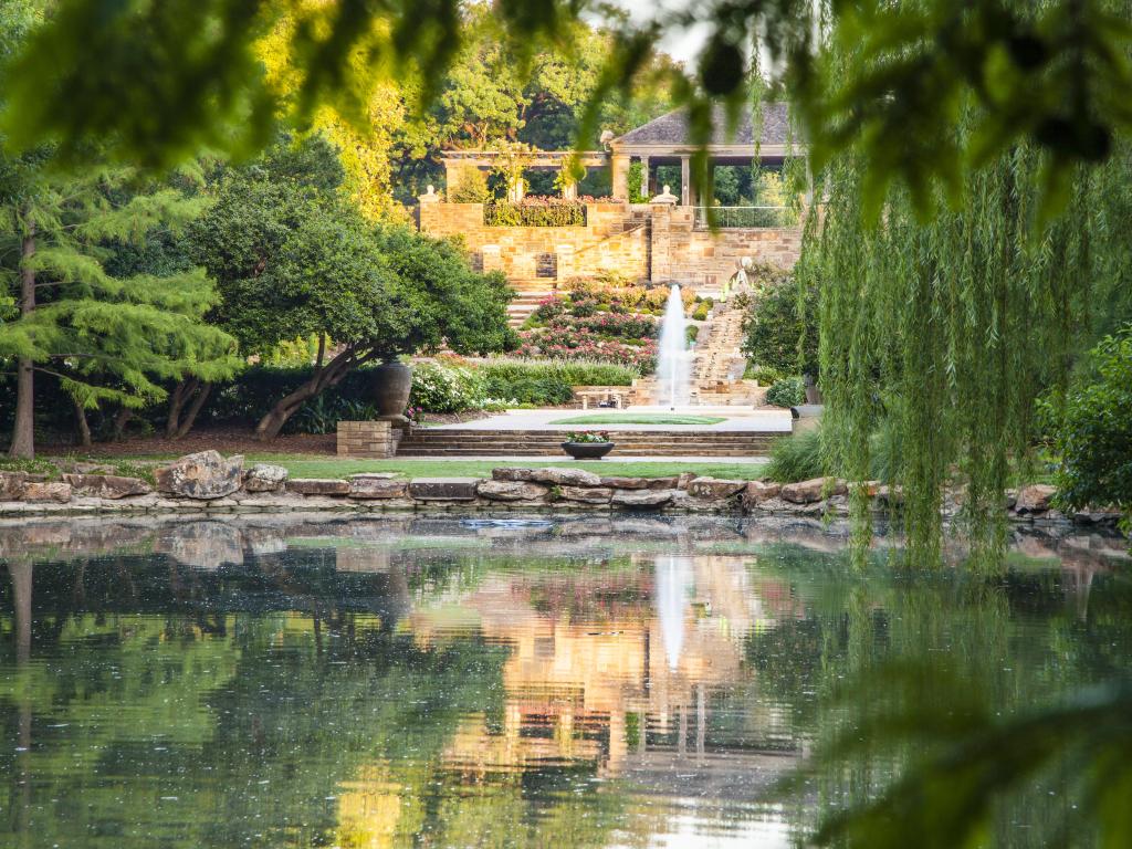 Tranquil pond with reflections at Fort Worth Botanical Garden on a bright day