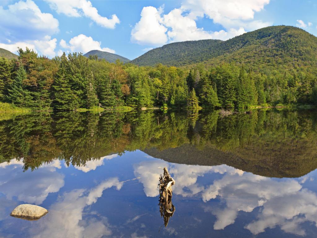 Adirondack Mountains, New York State, USA with a panoramic view of Phelps Mt, Mt Marcy and Mt. Colden reflected in Marcy Dam Pond in the High Peaks region on a sunny day.