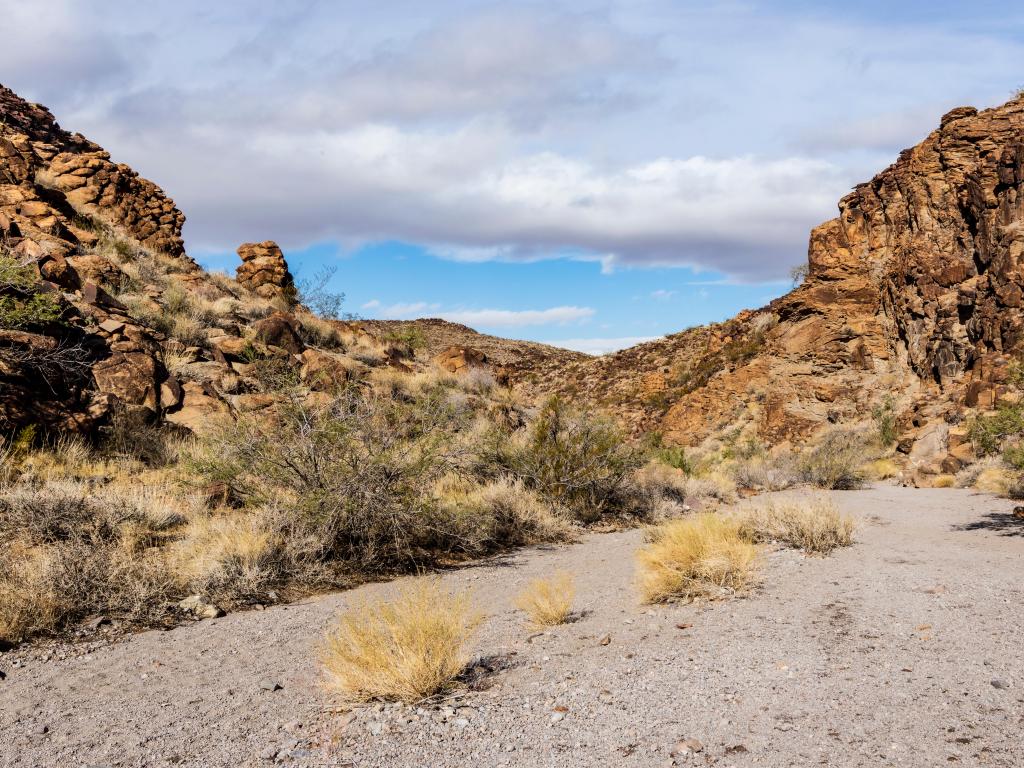 Sloan Canyon, Nevada, USA with a view of rocky cliffs taken on a sunny but cloudy day.