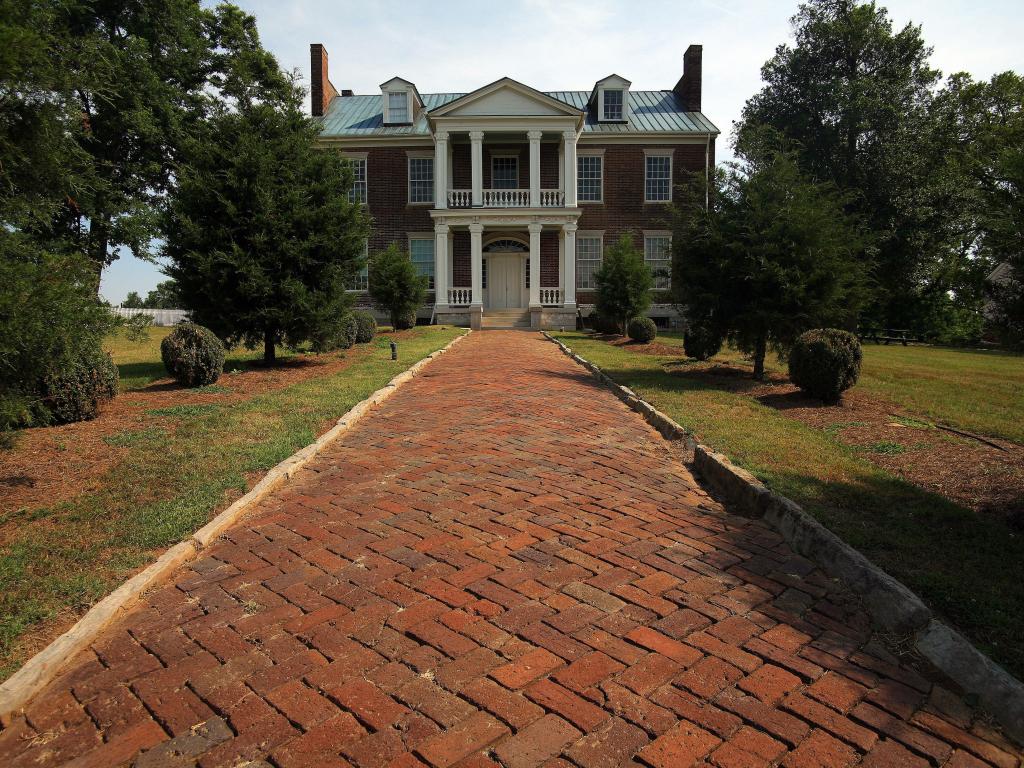 Carnton, TN, USA with red brick path leading to the house and trees either side.