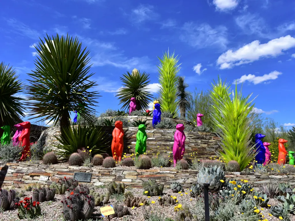 Colorful artwork with meerkat sculptures among desert plants in the garden in Phoenix
