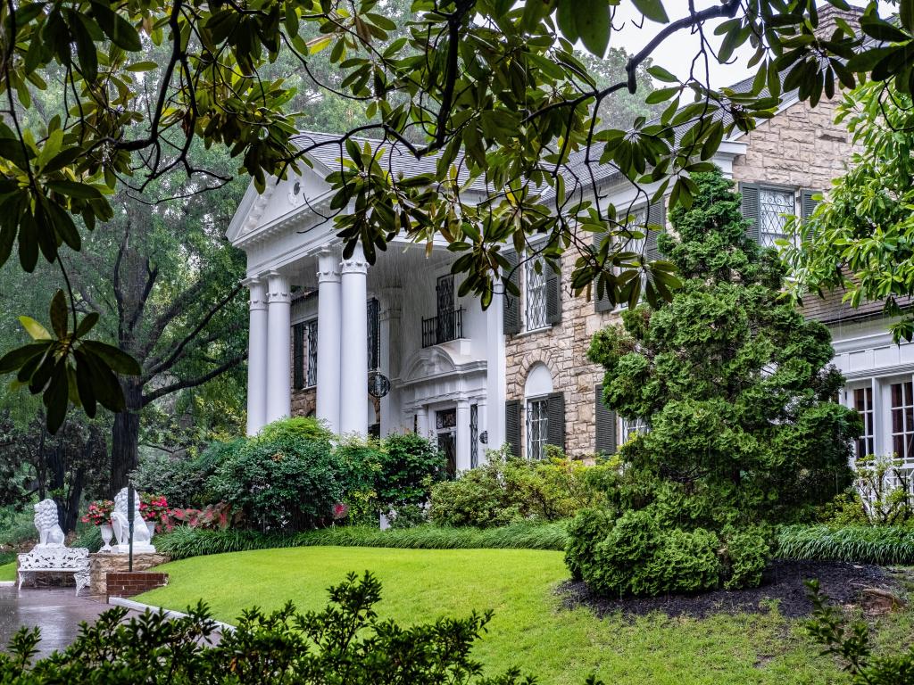 Elvis Presley's famous Graceland mansion in Memphis, Tennessee, seen through the lush garden vegetation