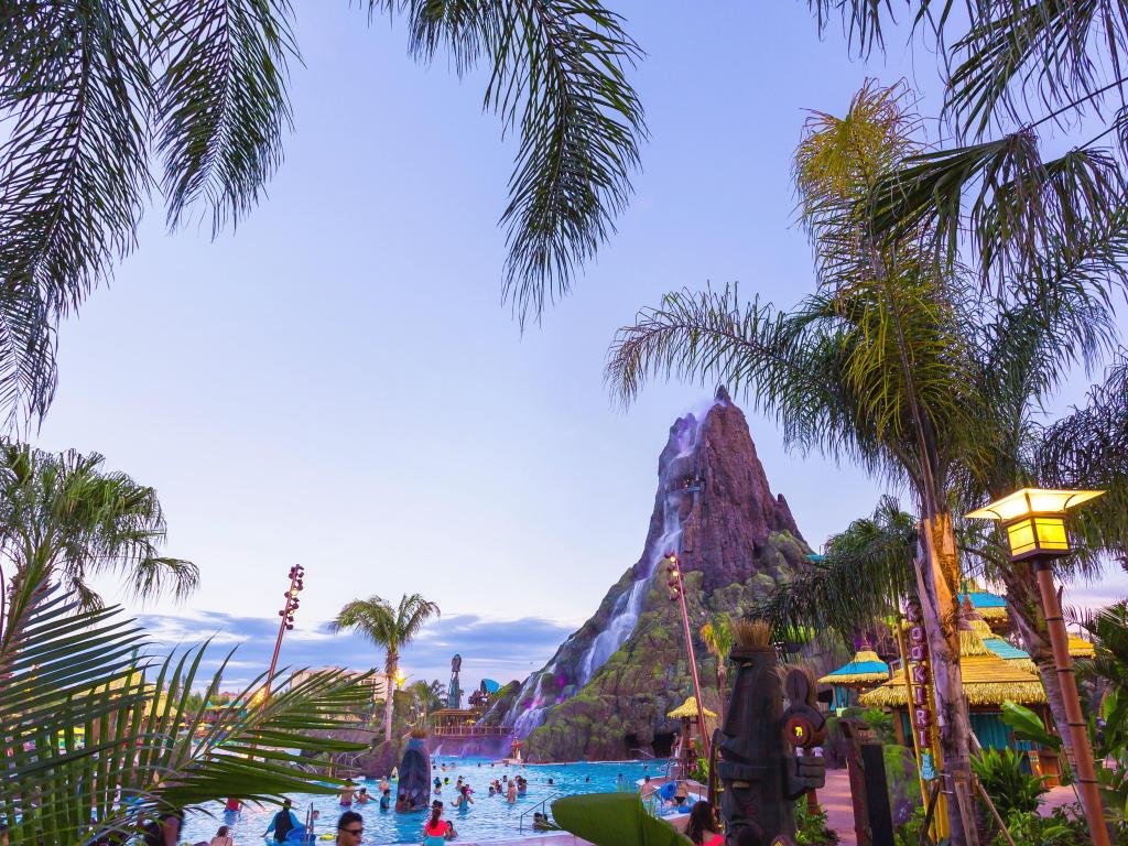 Guests enjoying a swim at Volcano Bay waterfall at sunset in Universal Studios, Orlando, Florida