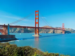 Famous red bridge on a sunny day with blue skies and blue ocean beneath