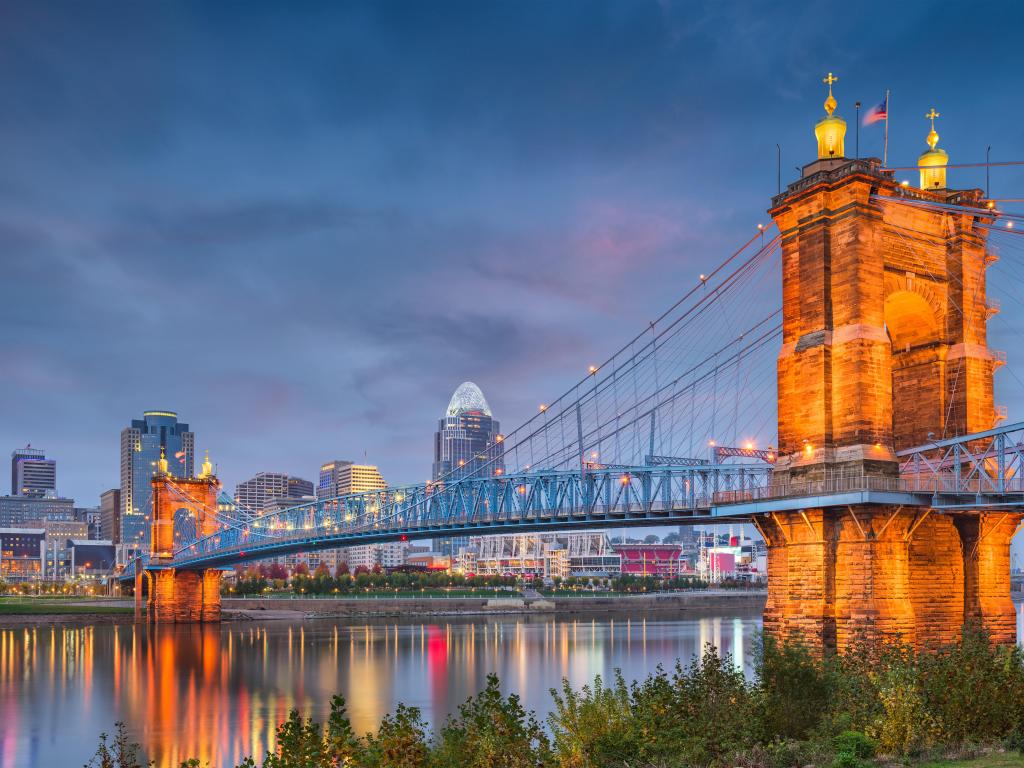 Cincinnati, Ohio skyline over the river at dusk with the bridge lit up