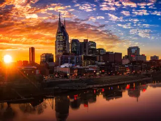 City skyline during fiery sunset with the moon already up in the sky