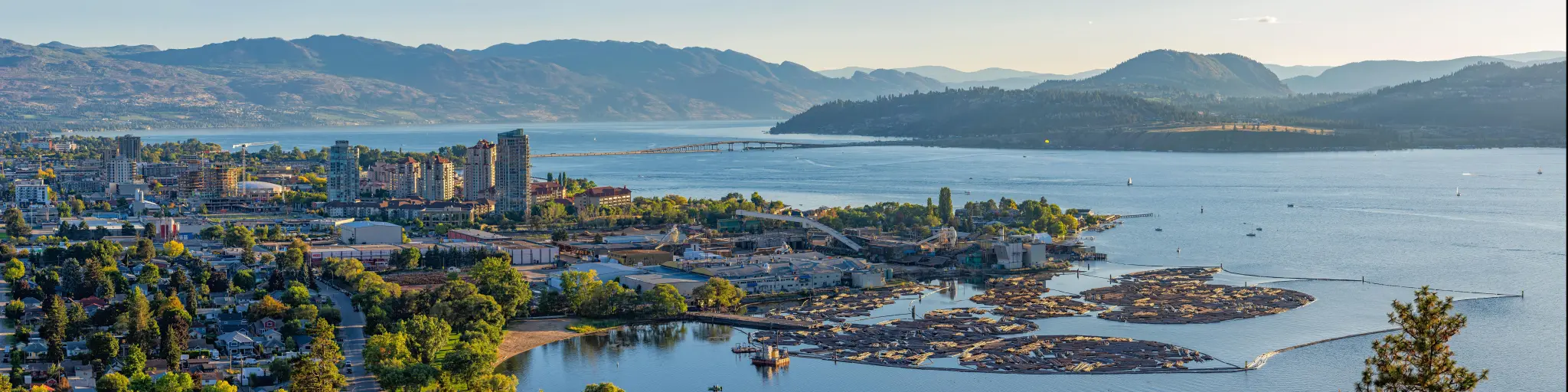 Kelowna, British Columbia, Canada with a high resolution panorama of the city skyline and Okanagan Lake with the R W Bennett Bridge in the background, from Knox Mountain at sunset.