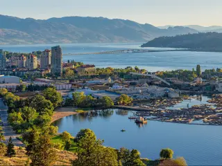 Kelowna, British Columbia, Canada with a high resolution panorama of the city skyline and Okanagan Lake with the R W Bennett Bridge in the background, from Knox Mountain at sunset.