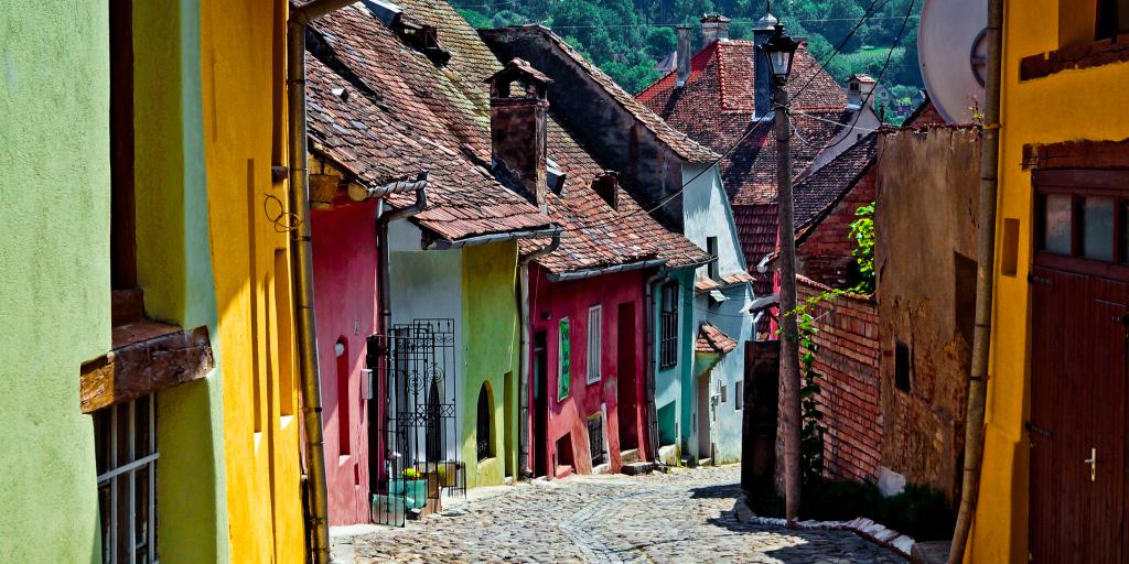 A cobbled street lined with pretty coloured houses in Sighisoara, Romania 