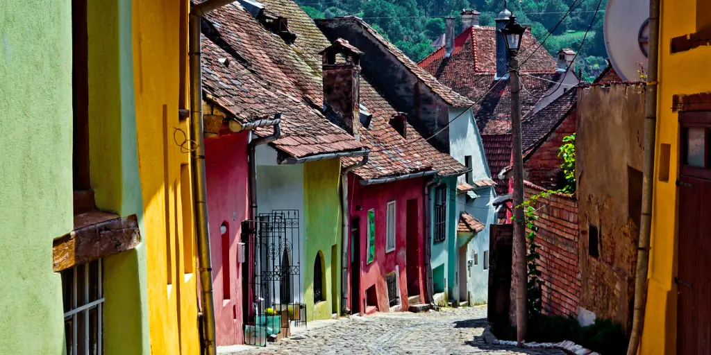 A cobbled street lined with pretty coloured houses in Sighisoara, Romania 