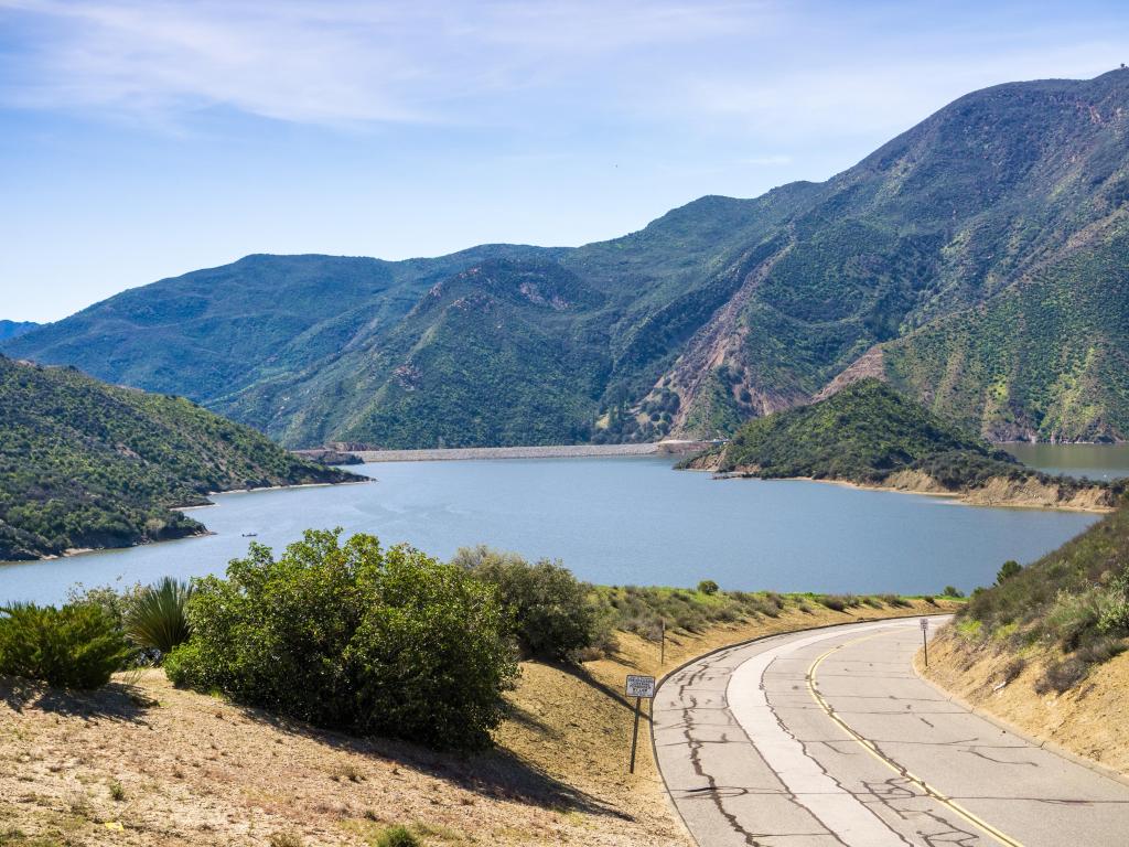 Road leading to Pyramid Lake in Los Angeles County, California on a sunny day, with the Lake in the background