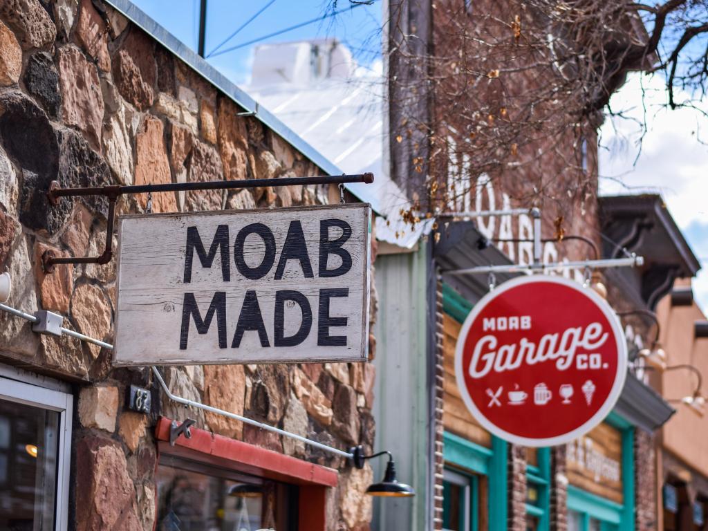 Sign for Moab Made shop in downtown Moab and red sign of Moab Garage Co