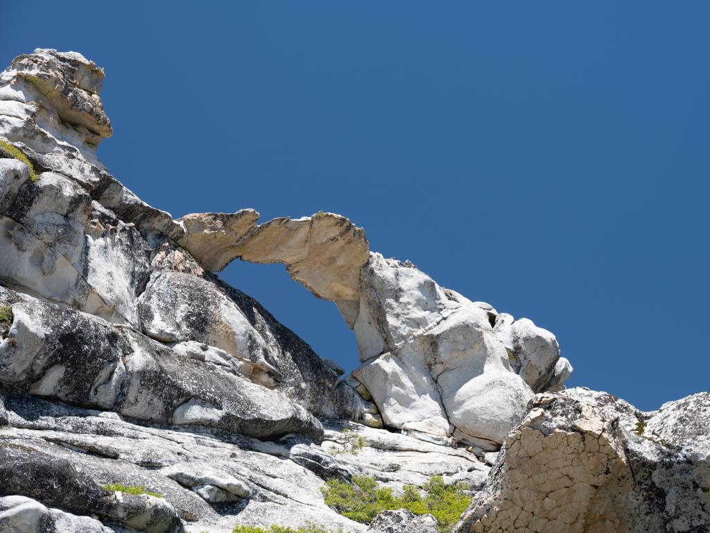 Natural white rock arch against the blue sky