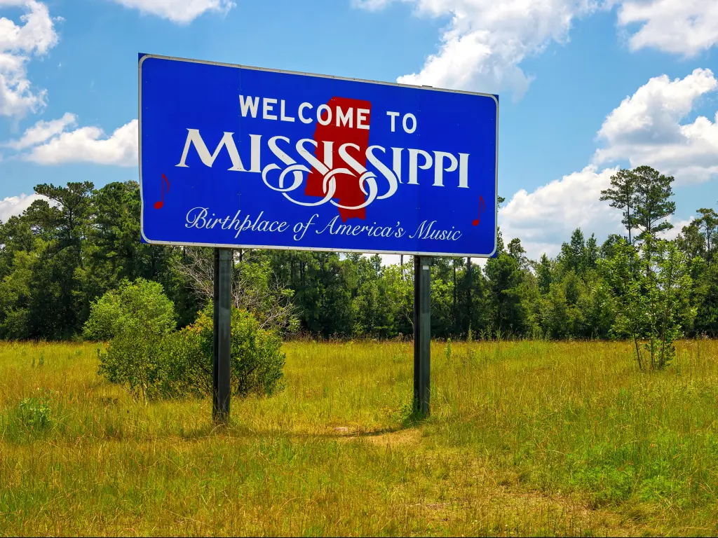 Blue welcome sign at the roadside on entering the state of Mississippi: reads "Birthplace of America's Music"