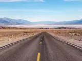 Road leading into Death Valley with blue skies ahead