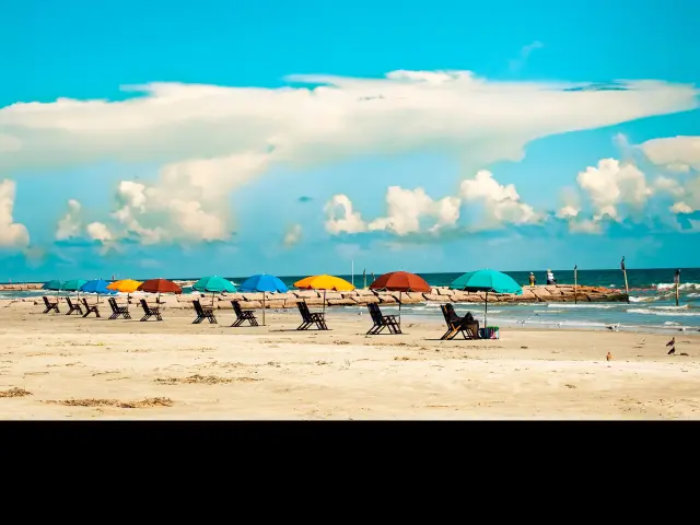 Colorful umbrellas and sun loungers on the beach of Galveston Island, Texas