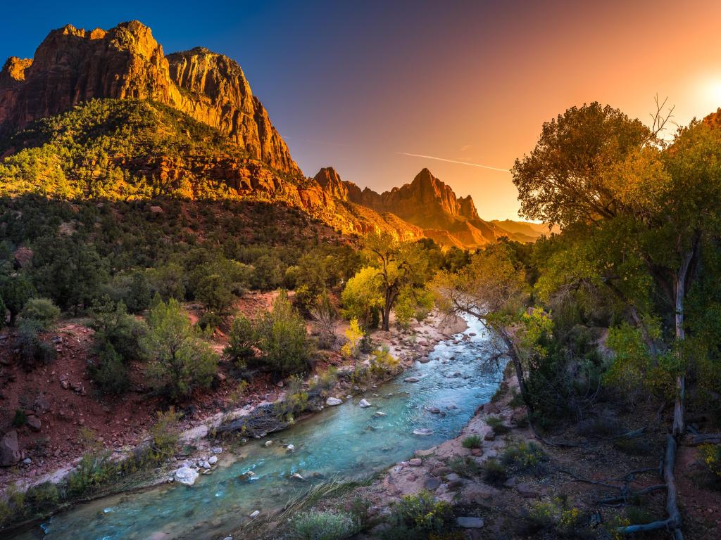 A river running through the mountains in Zion National Park at sunset.