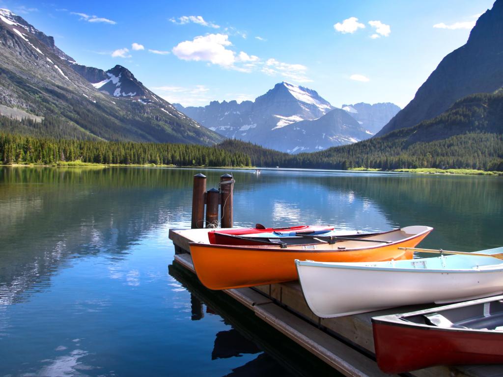 Glacier National Park, Montana, USA with canoes by Lake McDonald with the mountains in the distance on a sunny day.