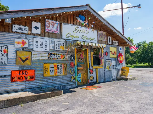 Metal storefront with road signs at Joie's Cajun Market on Sowell Mill Pike near Columbia, TN