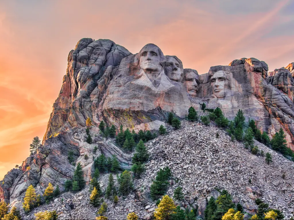 Mount Rushmore National Memorial, Black Hills region of South Dakota, USA with the famous four heads of four previous presidents carved into the granite cliffs and a red sky above.