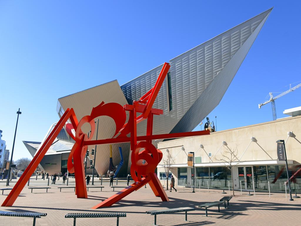 The facade of the museum on a sunny day with a red installation in the foreground