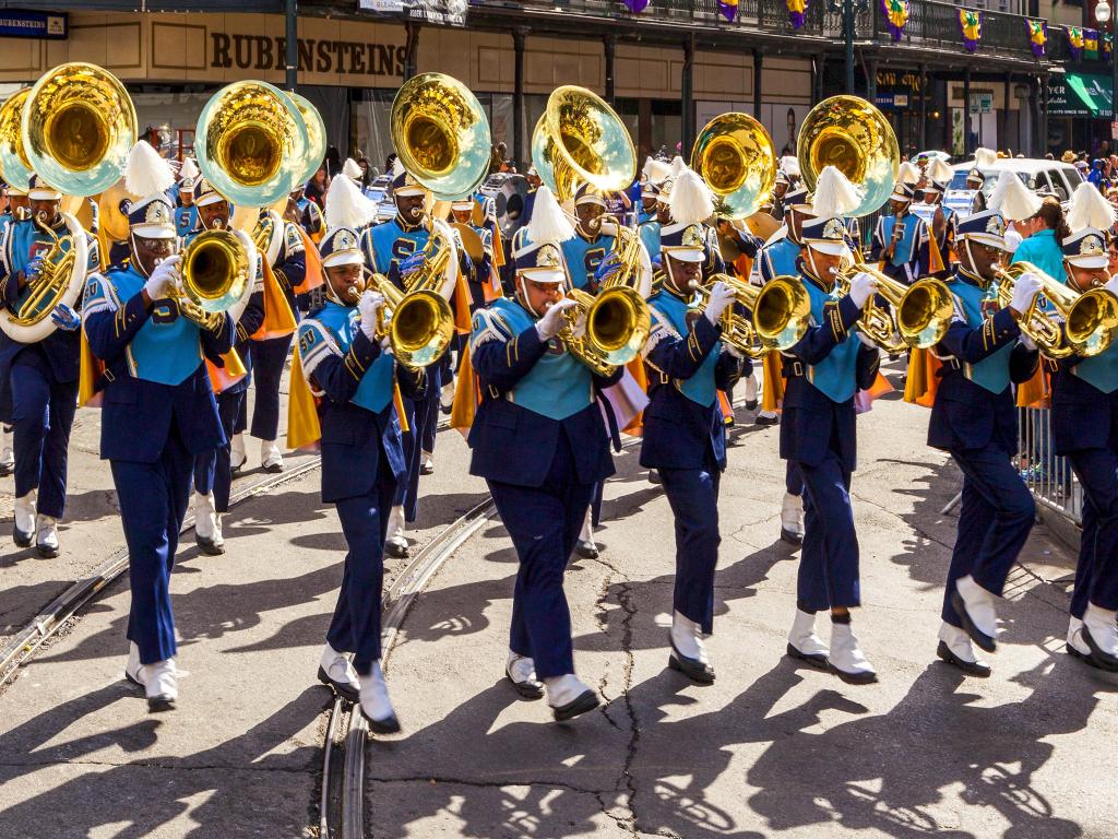 Close up of the horn section of a marching band in a New Orleans street on a summer's day during Mardi Gras