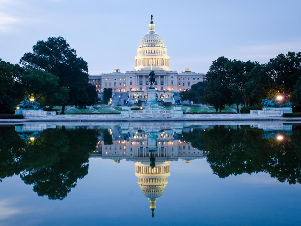 Washington DC, US Capitol Building in a cloudy sunrise with mirror reflection