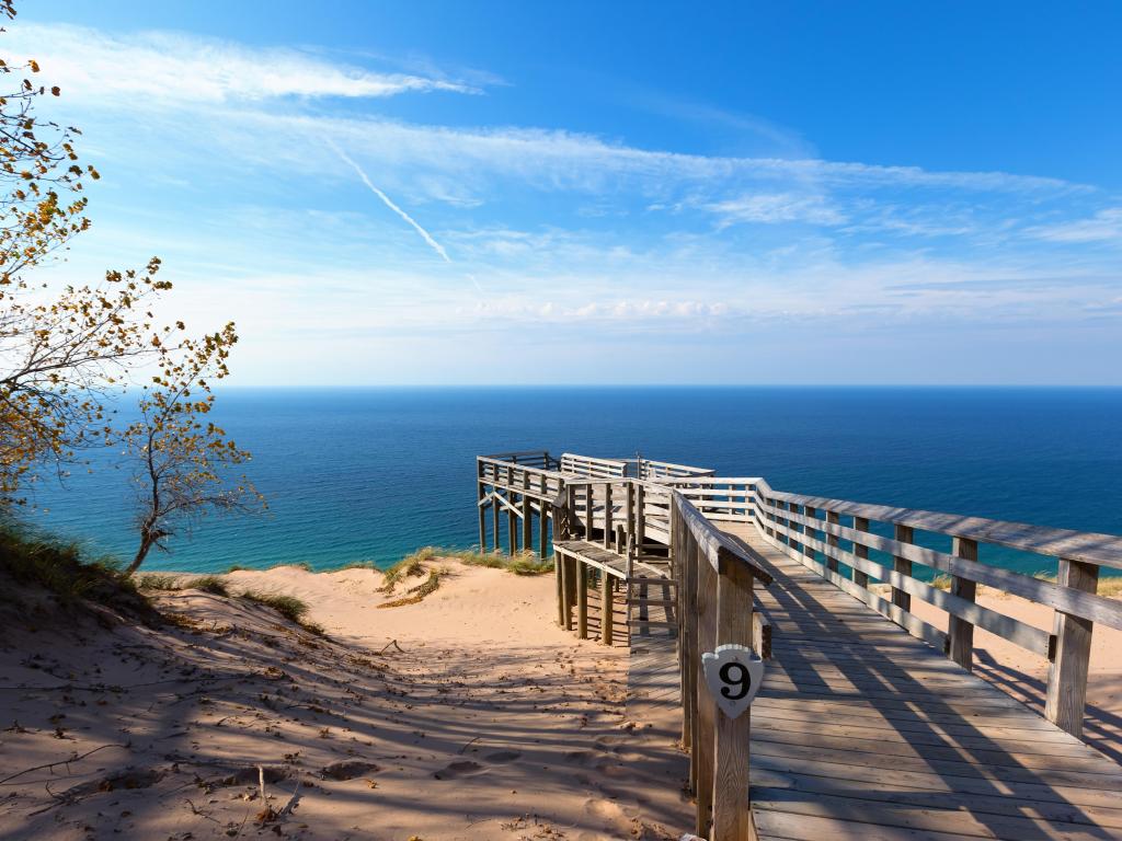 A wooden walkway to a bright white beach followed by the clearest waters and blue sky