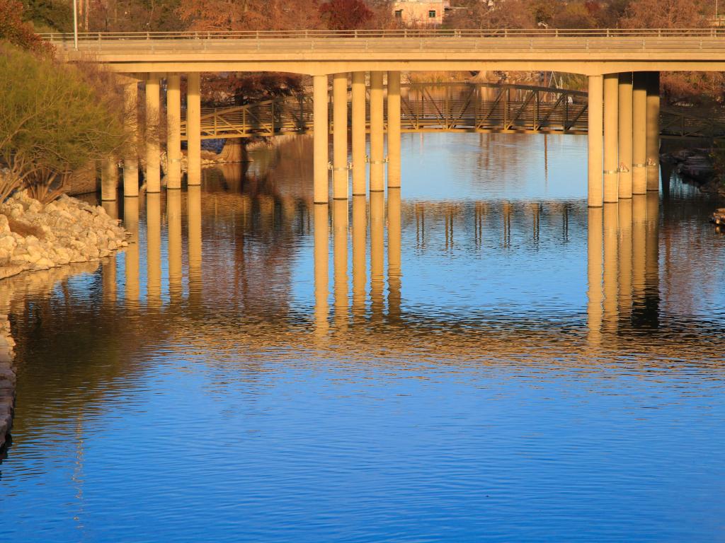 Sandy coloured bridge over calm river in late afternoon light