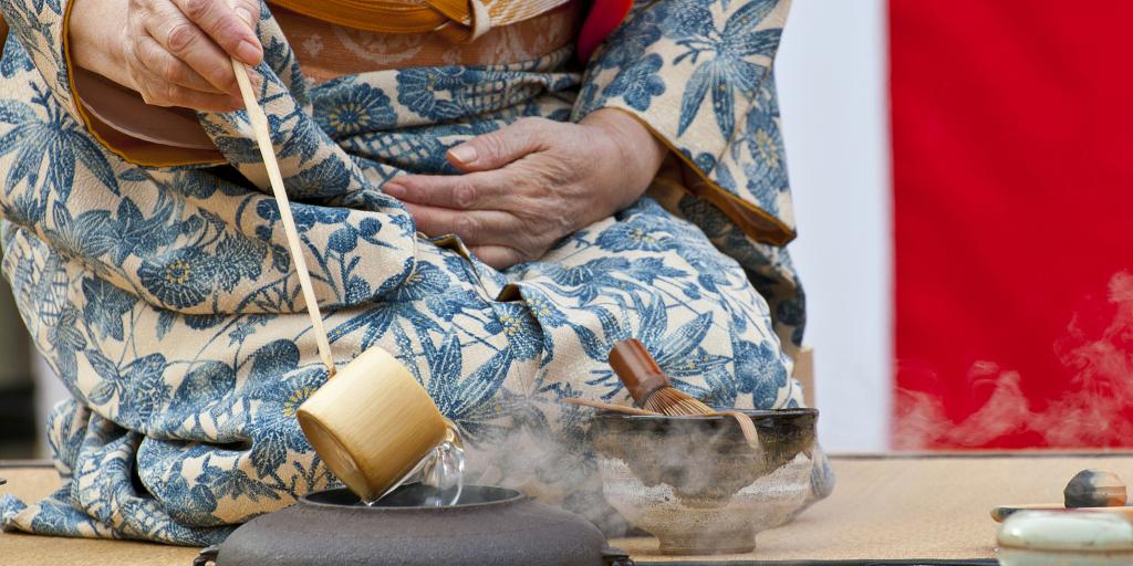 A person in a kimono performing a Japanese tea ceremony 