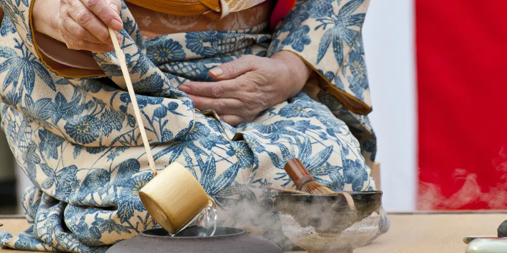 A person in a kimono performing a Japanese tea ceremony 