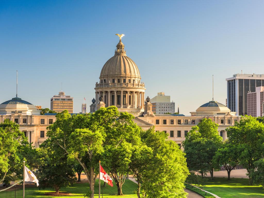 Jackson, Mississippi, USA taken at downtown cityscape at the capitol on a sunny day with trees in the foreground. 