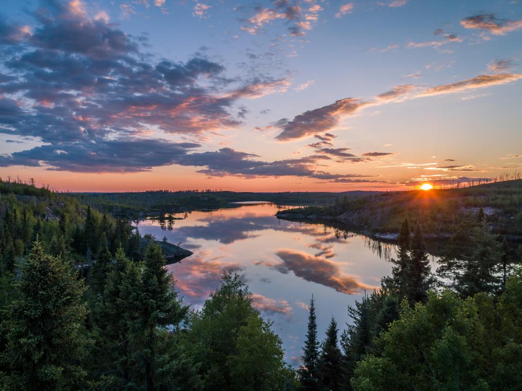 Beautiful sunset over the lake, surrounded by forests