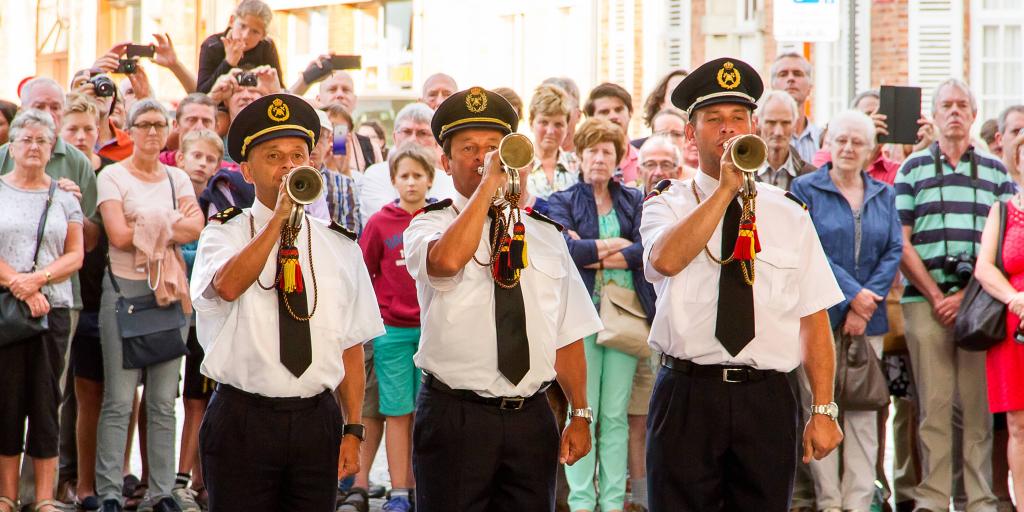 Buglers from Ypres volunteer Fire Brigade sound The Last Post with a crowd behind them