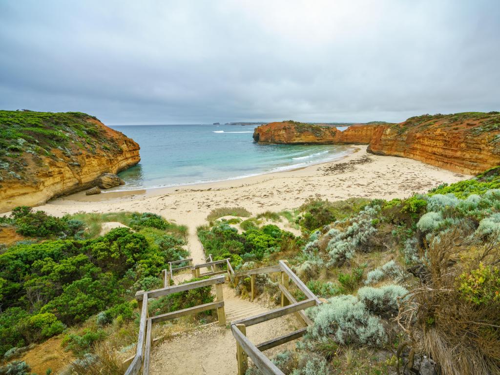 Walkway down to the Bay of Martyrs in the forefront, with rock formations and coastline behind, Great Ocean Road, Australia