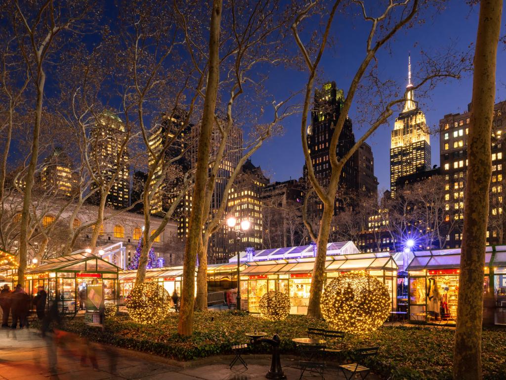 Bryant Park Winter Village in evening with the Empire State Building in the background